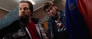 Movie still from “Four Brothers” (2005), directed by John Singleton – Two men standing next to each other in front of a brick wall; Medium shot, Low angle