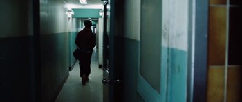 Movie still from “Four Brothers” (2005), directed by John Singleton – A person walking down a hallway in a building; Wide shot, Low angle