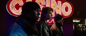 Movie still from “Four Brothers” (2005), directed by John Singleton – A group of men standing next to each other in front of a neon sign; Medium shot, Low angle