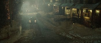 Movie still from “Four Brothers” (2005), directed by John Singleton – Cars driving down a street in the rain at night; Extreme Wide shot, High angle