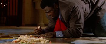 Movie still from “Four Brothers” (2005), directed by John Singleton – A man in a red apron is cutting food; Close Up shot, High angle