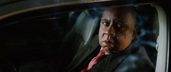 Movie still from “Four Brothers” (2005), directed by John Singleton – A person wearing a suit in a car; Close Up shot, Low angle