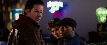 Movie still from “Four Brothers” (2005), directed by John Singleton – A group of men standing next to each other in front of neon lights; Close Up shot, Low angle