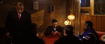 Movie still from “Four Brothers” (2005), directed by John Singleton – A group of people sitting around a table; Medium shot, High angle