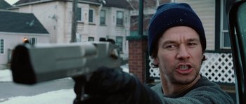 Movie still from “Four Brothers” (2005), directed by John Singleton – A man holding a gun while standing in front of a building; Close Up shot, Over the shoulder angle
