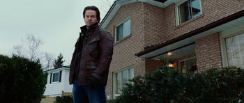Movie still from “Four Brothers” (2005), directed by John Singleton – A man standing in front of a brick house; Medium shot, Low angle