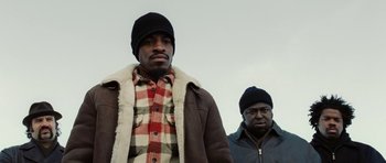 Movie still from “Four Brothers” (2005), directed by John Singleton – Two men standing next to each other in winter clothing; Medium shot, Low angle