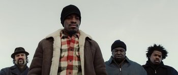 Movie still from “Four Brothers” (2005), directed by John Singleton – Two men standing next to each other in winter clothing; Medium shot, Low angle