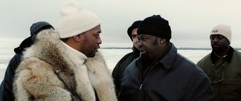 Movie still from “Four Brothers” (2005), directed by John Singleton – A group of men standing next to each other on a beach; Medium shot, Over the shoulder angle