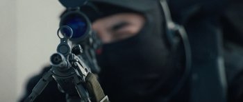 Movie still from “Four Brothers” (2005), directed by John Singleton – A person with a rifle in the foreground and in the background; Extreme Close Up shot, Low angle