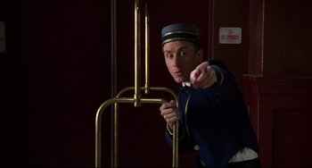 Movie still from “Four Rooms” (1995), directed by Robert Rodriguez – A man wearing a uniform points to the camera; Medium shot, Low angle