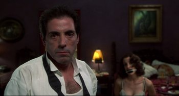 Movie still from “Four Rooms” (1995), directed by Robert Rodriguez – A man and a woman are in a dark room; Close Up shot, Low angle