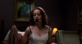 Movie still from “Four Rooms” (1995), directed by Robert Rodriguez – A woman in a white dress holding a knife in her mouth; Close Up shot, Low angle