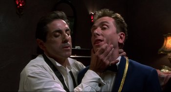 Movie still from “Four Rooms” (1995), directed by Robert Rodriguez – A man is putting a tie on another man's neck; Close Up shot, Low angle