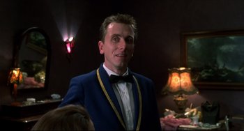 Movie still from “Four Rooms” (1995), directed by Robert Rodriguez – A man in a blue suit and a yellow bow tie; Close Up shot, Low angle