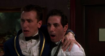 Movie still from “Four Rooms” (1995), directed by Robert Rodriguez – Two men in tuxedos are posing for a picture; Close Up shot, Low angle