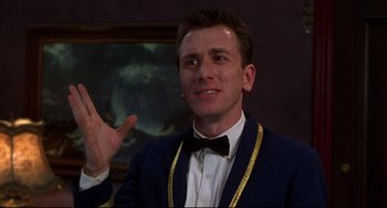 Movie still from “Four Rooms” (1995), directed by Robert Rodriguez – A man in a suit and bow tie holding his hand up; Close Up shot, Low angle