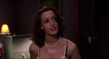 Movie still from “Four Rooms” (1995), directed by Robert Rodriguez – A woman wearing a white bra and a white necklace; Close Up shot, Over the shoulder angle