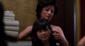 Movie still from “Four Rooms” (1995), directed by Robert Rodriguez – A young girl getting her hair brushed by a woman; Close Up shot, Over the shoulder angle