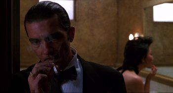 Movie still from “Four Rooms” (1995), directed by Robert Rodriguez – A man in a tuxedo smoking a cigarette in front of a mirror; Close Up shot, Low angle