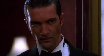 Movie still from “Four Rooms” (1995), directed by Robert Rodriguez – A person wearing a suit and tie; Close Up shot, Low angle