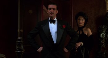 Movie still from “Four Rooms” (1995), directed by Robert Rodriguez – A man in a tuxedo standing next to a woman in a black dress; Medium shot, Low angle