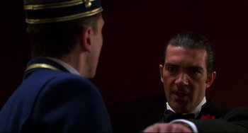 Movie still from “Four Rooms” (1995), directed by Robert Rodriguez – A man in a suit and tie talking to another man in a suit and tie; Close Up shot, Over the shoulder angle
