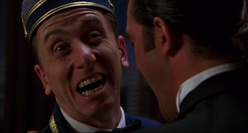 Movie still from “Four Rooms” (1995), directed by Robert Rodriguez – A man in a uniform and a man in a suit talking to each other; Close Up shot, Low angle