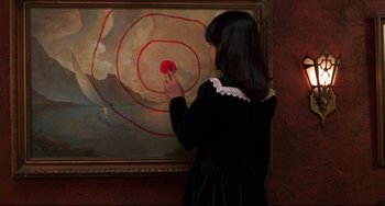 Movie still from “Four Rooms” (1995), directed by Robert Rodriguez – A young girl is painting a picture on a wall; Medium shot, Overhead angle