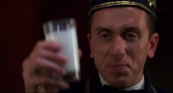 Movie still from “Four Rooms” (1995), directed by Robert Rodriguez – A person holding a glass of milk; Close Up shot, Low angle