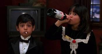 Movie still from “Four Rooms” (1995), directed by Robert Rodriguez – A young girl and a young boy are drinking alcohol; Medium shot, Low angle