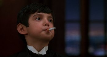 Movie still from “Four Rooms” (1995), directed by Robert Rodriguez – A young boy is smoking a cigarette while wearing a suit; Close Up shot, Low angle