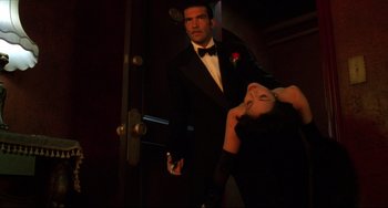 Movie still from “Four Rooms” (1995), directed by Robert Rodriguez – A man and a woman in tuxedos in front of an open door; Medium shot, Low angle