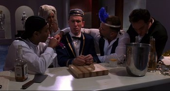 Movie still from “Four Rooms” (1995), directed by Robert Rodriguez – A group of people sitting around a table; Medium shot, Over the shoulder angle