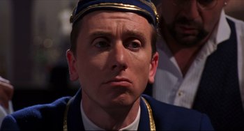 Movie still from “Four Rooms” (1995), directed by Robert Rodriguez – A person wearing a uniform; Close Up shot, Over the shoulder angle