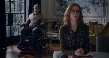 Movie still from “The Upside” (2017), directed by Neil Burger – A woman sitting in a chair in front of a man; Medium shot, Over the shoulder angle