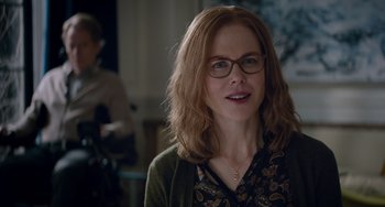 Movie still from “The Upside” (2017), directed by Neil Burger – A person wearing glasses and smiling; Close Up shot, Over the shoulder angle