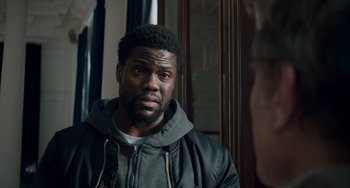 Movie still from “The Upside” (2017), directed by Neil Burger – A person wearing a jacket; Close Up shot, Over the shoulder angle