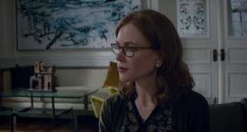 Movie still from “The Upside” (2017), directed by Neil Burger – A woman wearing glasses and a sweater looking to her left; Medium shot, Over the shoulder angle