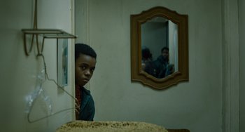 Movie still from “The Upside” (2017), directed by Neil Burger – A young man looking at himself in a mirror; Close Up shot, Over the shoulder angle