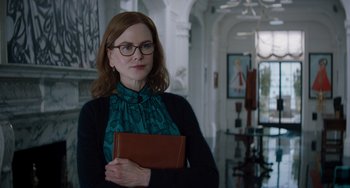 Movie still from “The Upside” (2017), directed by Neil Burger – A woman holding a book in a room; Medium shot, Low angle