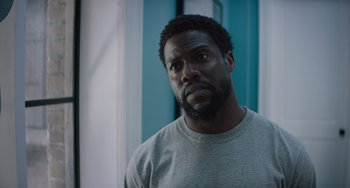 Movie still from “The Upside” (2017), directed by Neil Burger – A person wearing a gray shirt; Close Up shot, Over the shoulder angle