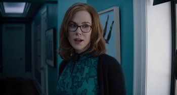 Movie still from “The Upside” (2017), directed by Neil Burger – A person wearing glasses and a sweater; Medium shot, Over the shoulder angle