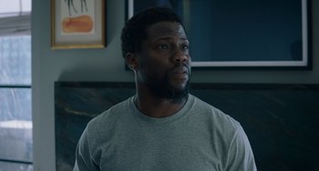 Movie still from “The Upside” (2017), directed by Neil Burger – A person wearing a gray t - shirt; Close Up shot, Over the shoulder angle