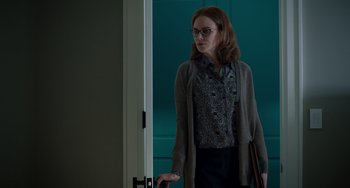 Movie still from “The Upside” (2017), directed by Neil Burger – A woman standing in front of a door wearing glasses; Medium shot, Low angle