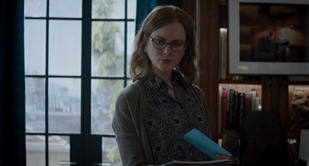 Movie still from “The Upside” (2017), directed by Neil Burger – A woman in glasses is looking at a book; Medium shot, Over the shoulder angle