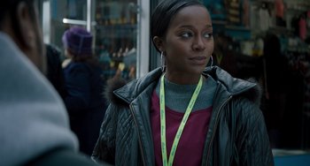 Movie still from “The Upside” (2017), directed by Neil Burger – A woman with a yellow lanyard around her neck; Close Up shot, Over the shoulder angle