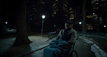 Movie still from “The Upside” (2017), directed by Neil Burger – An older man sitting in a wheelchair at night in a city park; Wide shot, High angle
