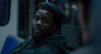 Movie still from “The Upside” (2017), directed by Neil Burger – A person wearing a hat; Close Up shot, Over the shoulder angle