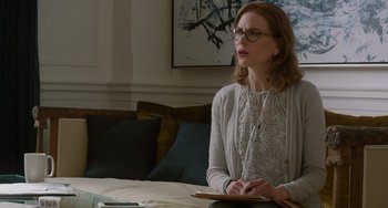 Movie still from “The Upside” (2017), directed by Neil Burger – A woman sitting at a table in front of a laptop; Medium shot, Over the shoulder angle